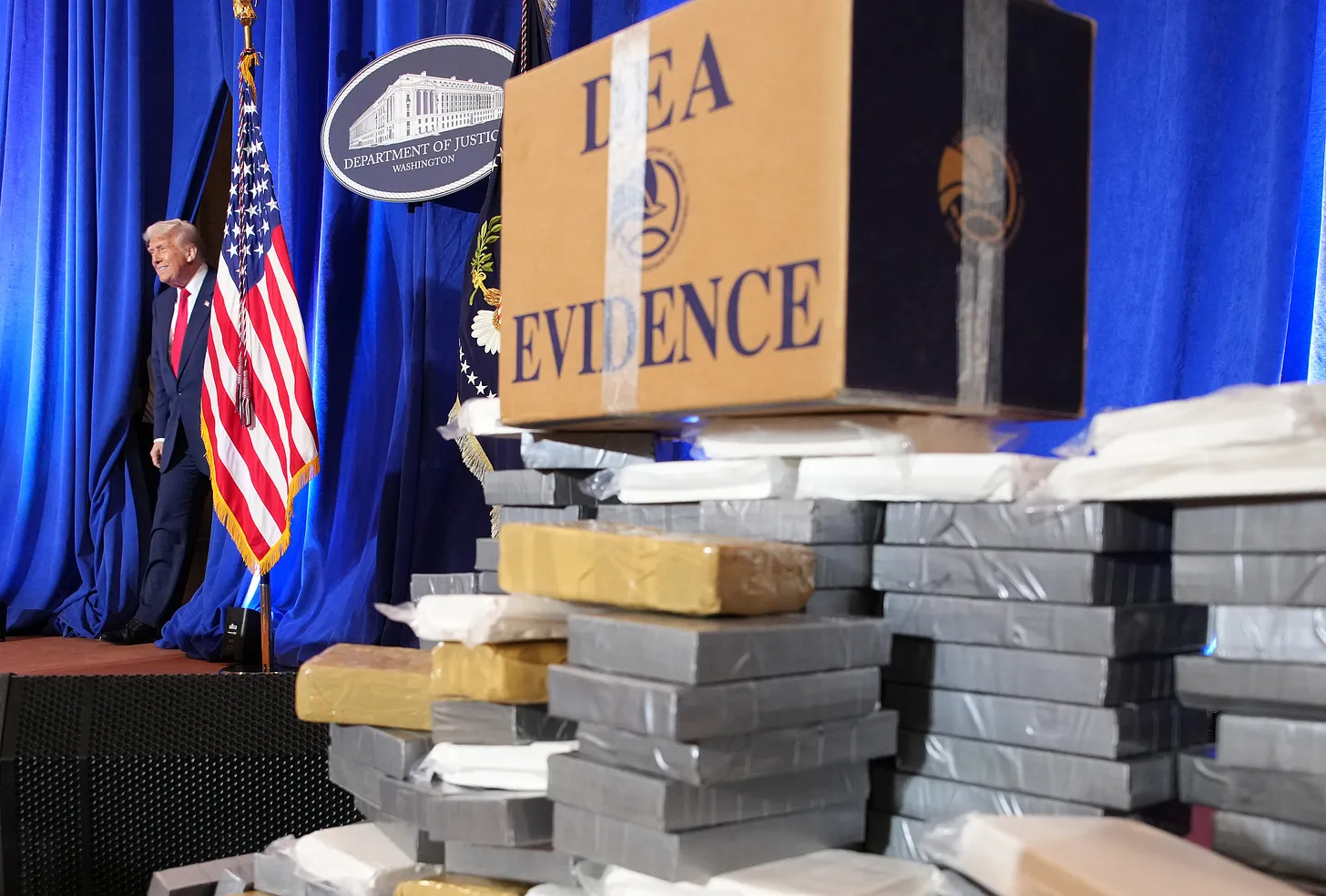 Drugs arrives to speak next to a pile of fake drugs yesterday at the DOJ