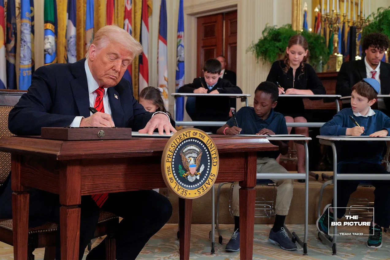 Trump signing next to school children