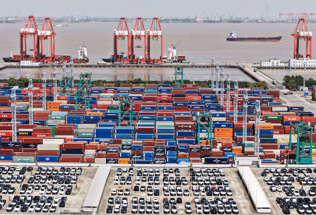 A drone view shows electric vehicles (EV) for export and containers sitting at a port in Shanghai, China April 13, 2025