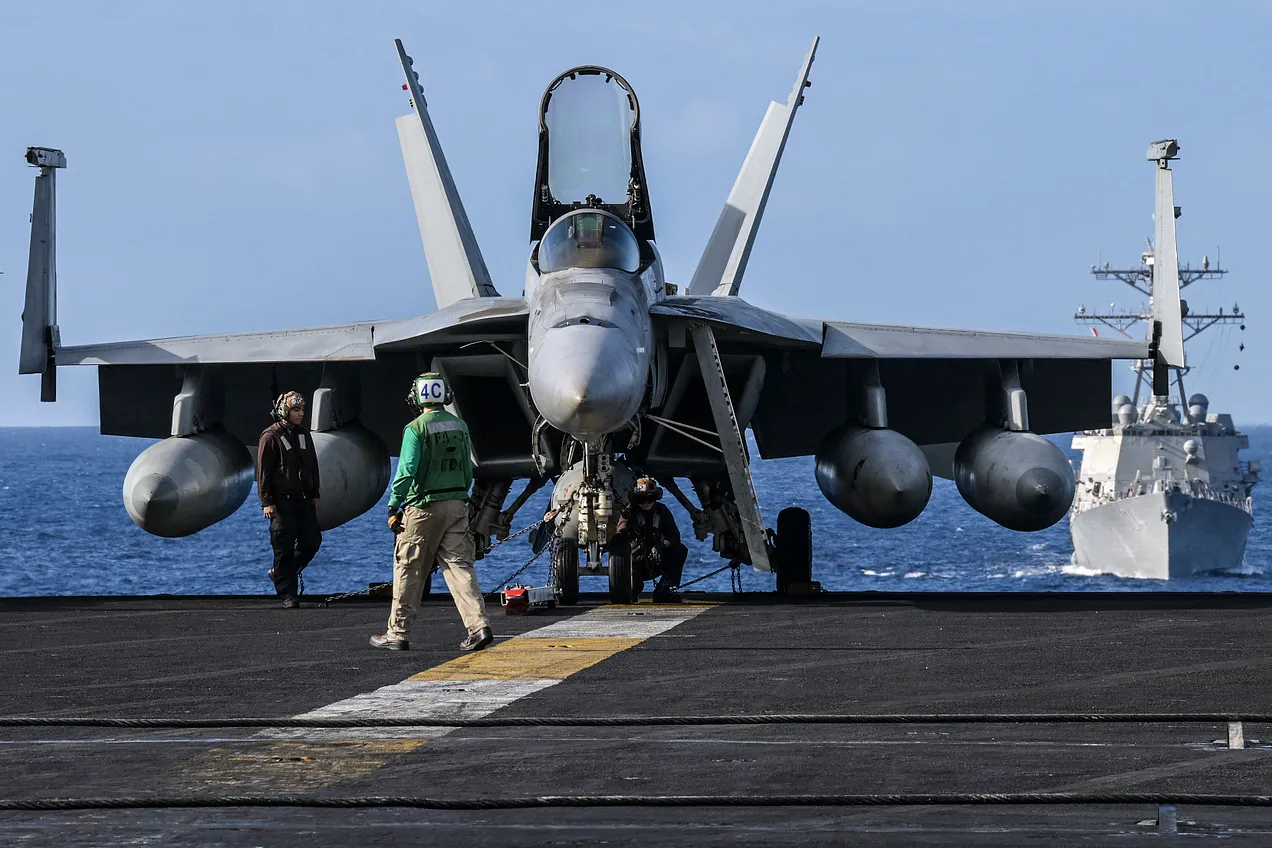 Crew members stand by an F/A-18 on the flight deck onboard the USS Carl Vinson aircraft carrier on January 31, 2024