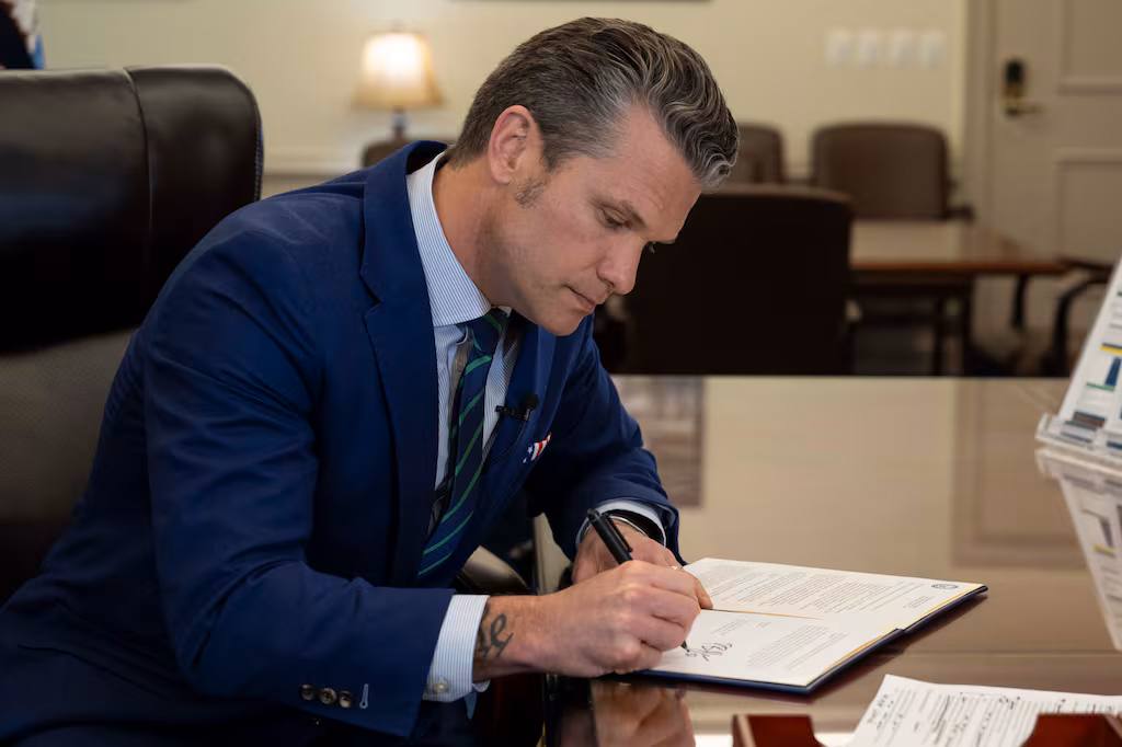 Secretary of Defense Pete Hegseth signs a memorandum at the Pentagon on April 23