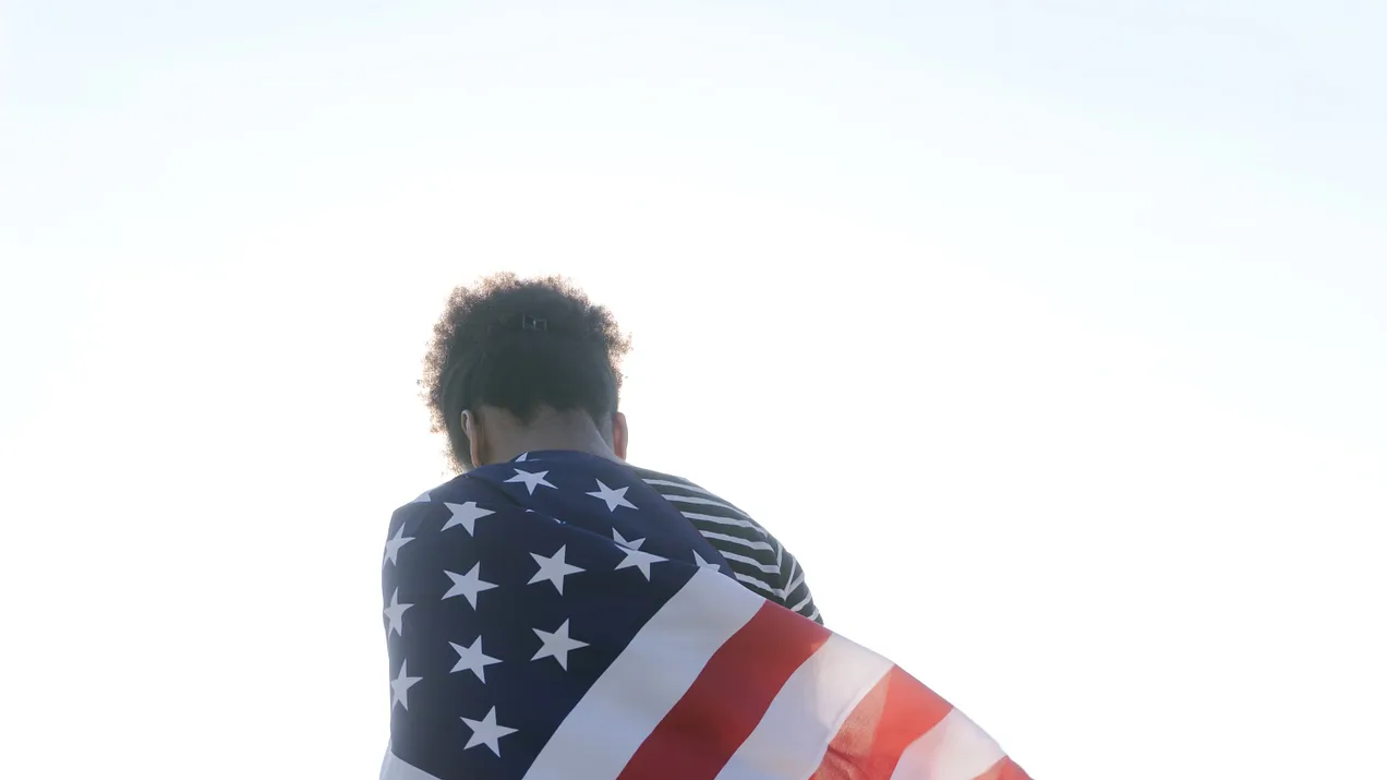 black person draped by US flag