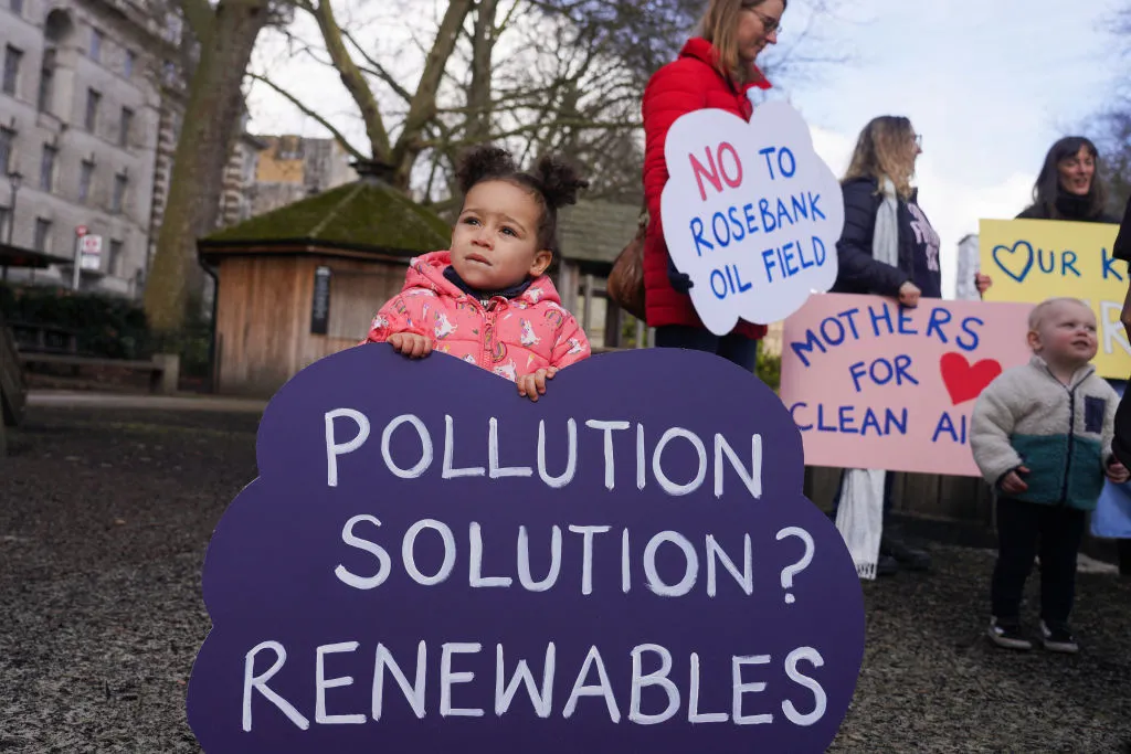 child with sign advocating renewables