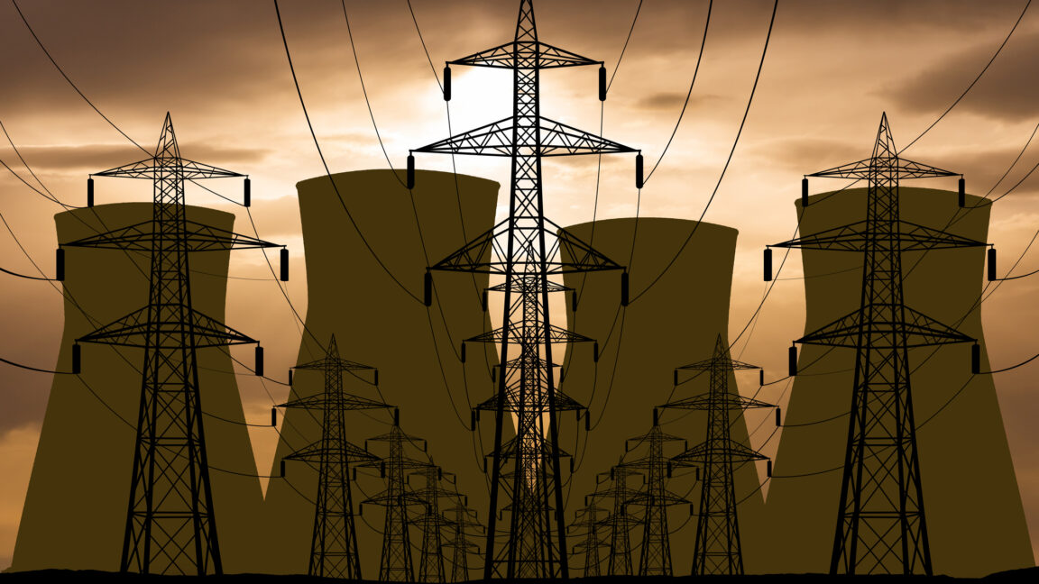 Nuclear power plant and power lines on the background of sunset