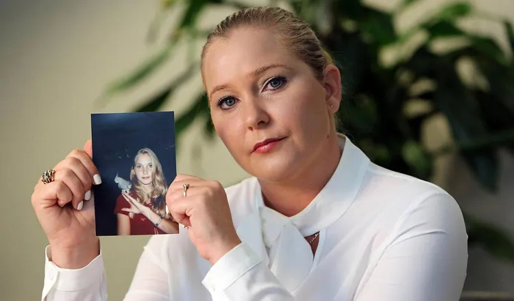 Virginia Roberts Giuffre poses with a photo of herself as a teen. (Emily Michot/Miami Herald via ZUMA Press Wire)
