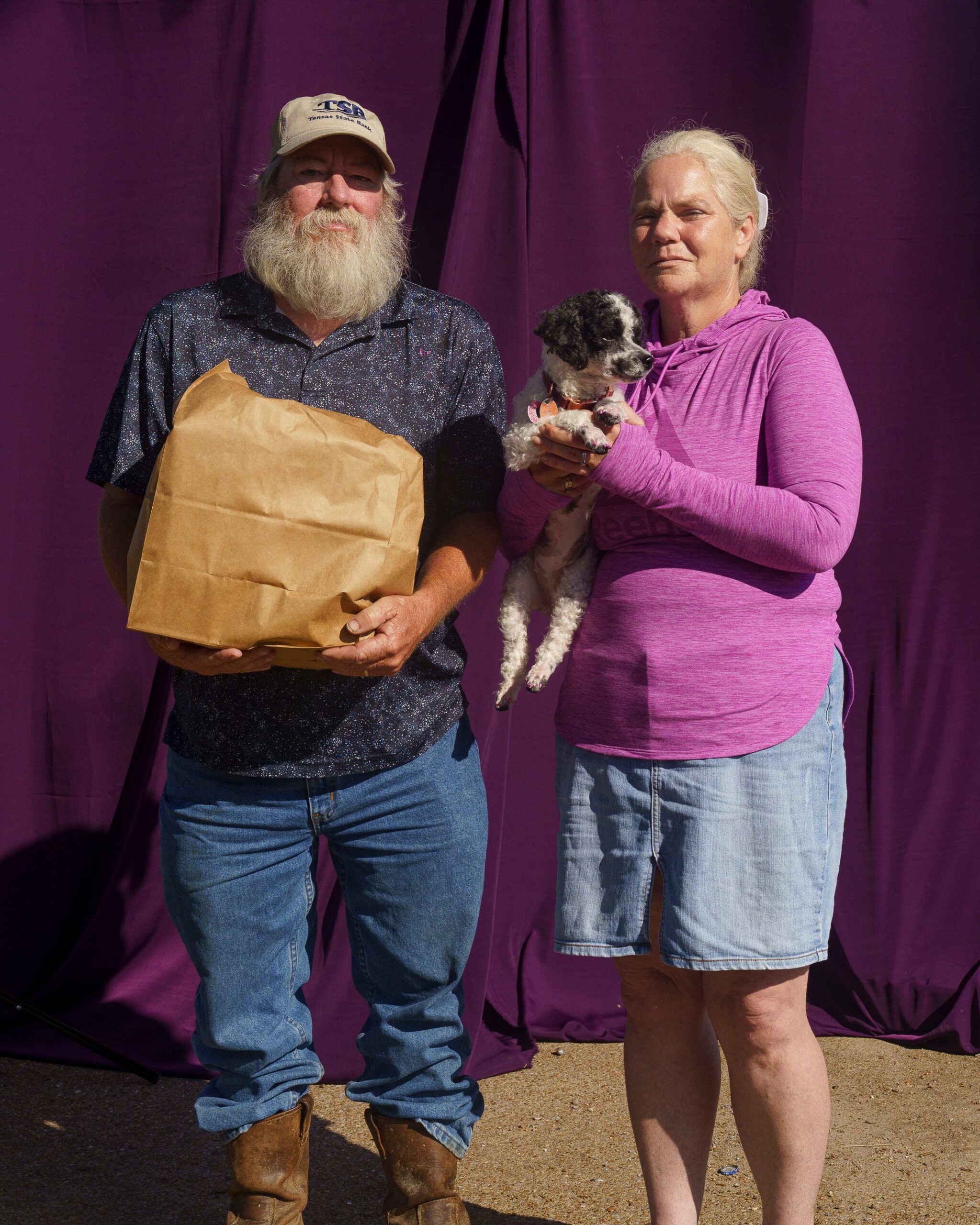 Shannan Cornwell, 50, and Freddie Green, 58, with their dog Stormy and a bag of groceries they received from a food bank.