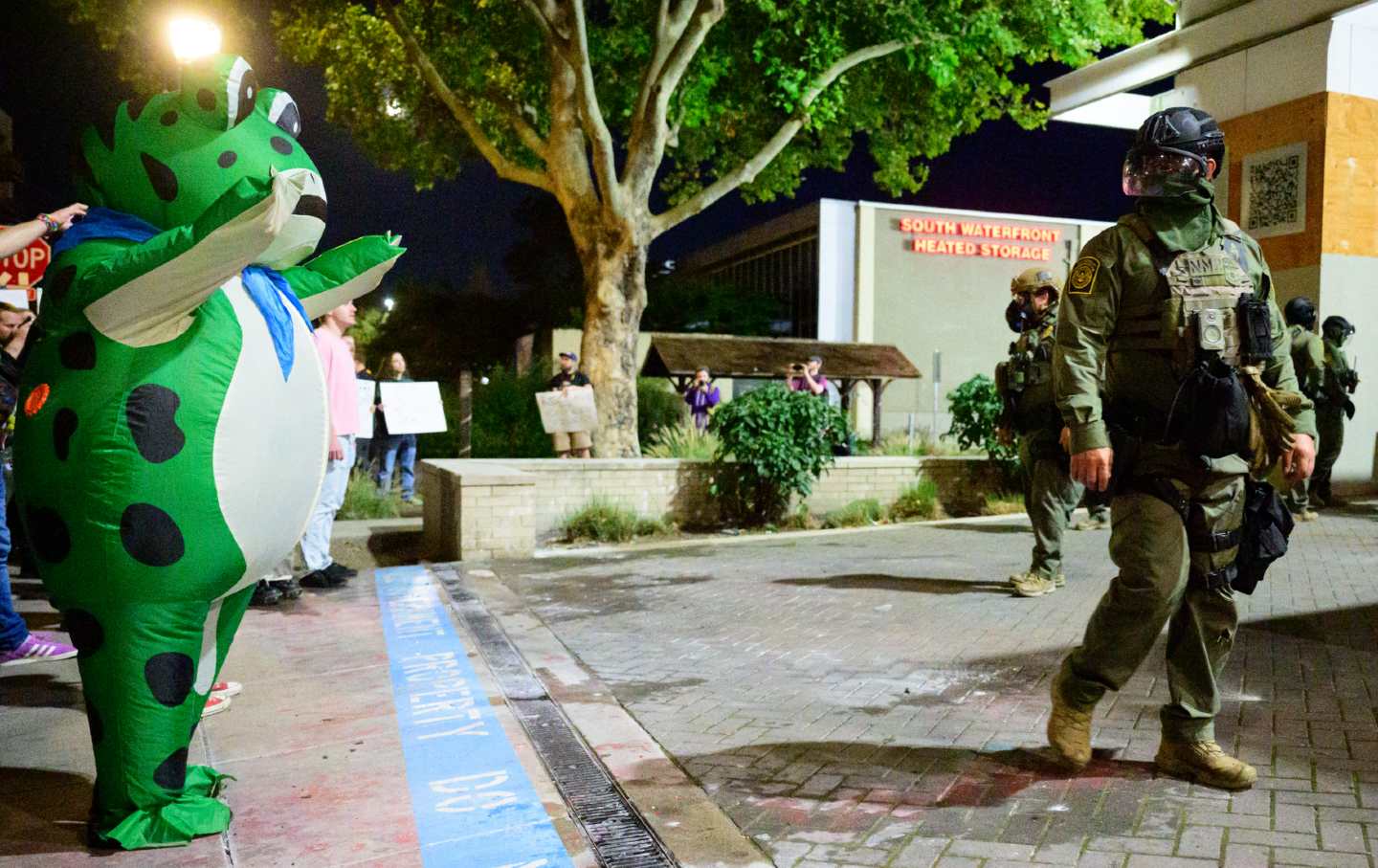 A protester in an inflatable frog costume puts a hex on ICE officer at a detention facility in Portland, Oregon, on October 6, 2025. (Mathieu Lewis-Rolland / AFP via Getty Images)