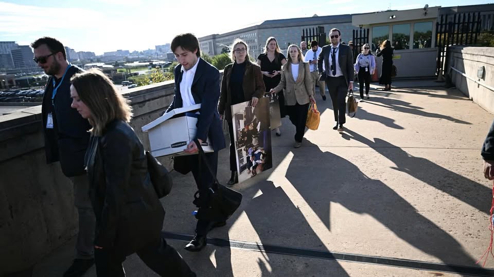 reporters carrying belongings out of Pentagon