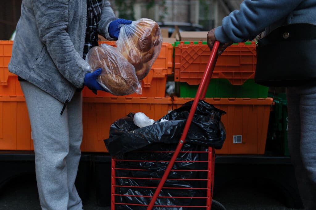 Volunteers distributing groceries at a church in New York this month.Credit...Marco Postigo Storel for The New York Times