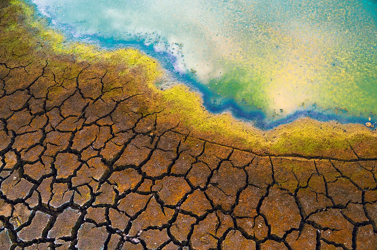 A polluted river edges up to drought-stricken land. Photo: Solid Photos / Adobe Stock.