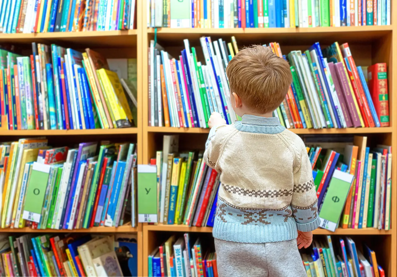 child looking at book shelves