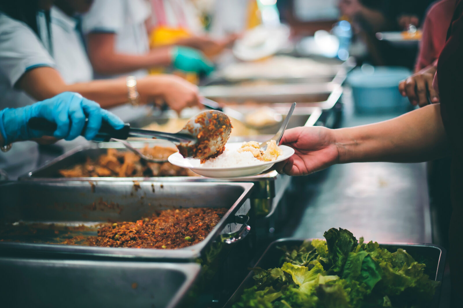 Starving homeless people receive food from volunteers