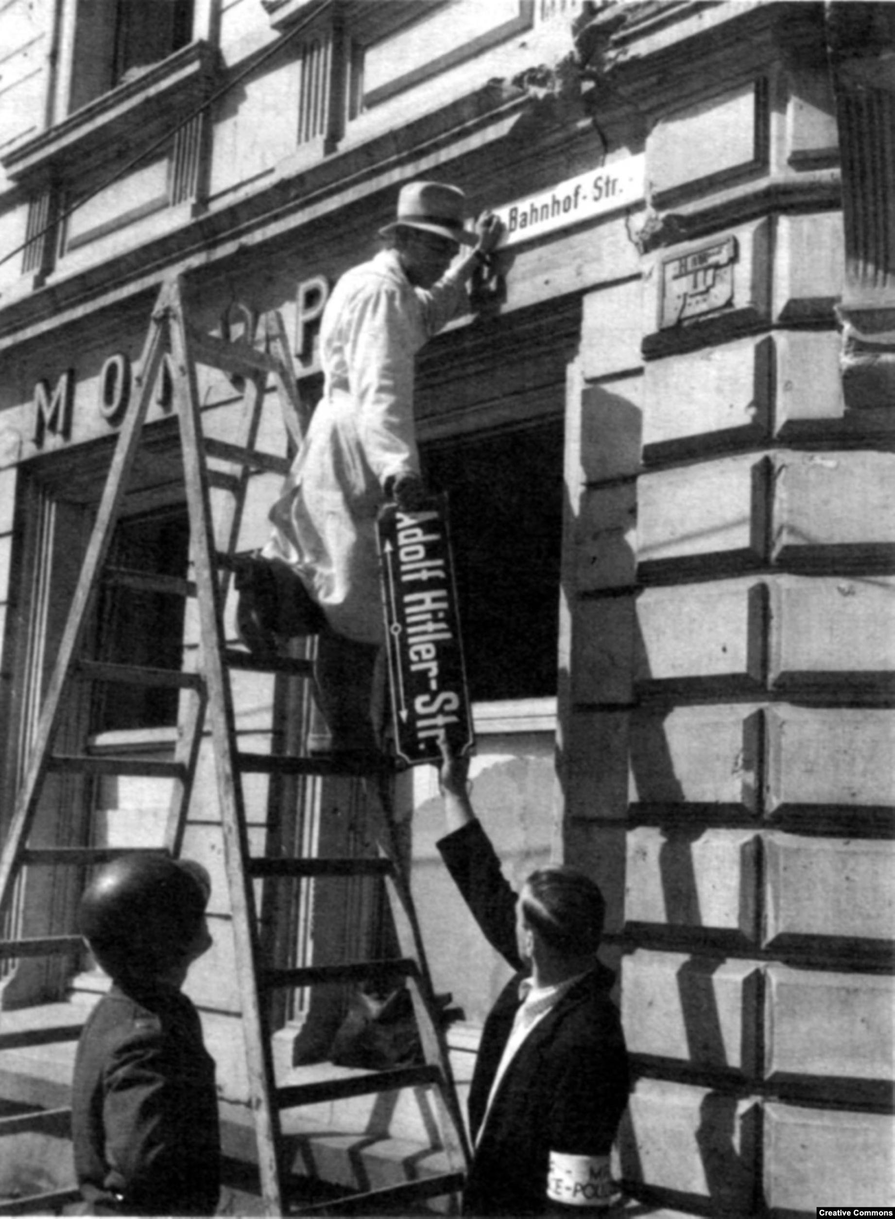 workers removing the signage for Adolf Hitler street in 1945