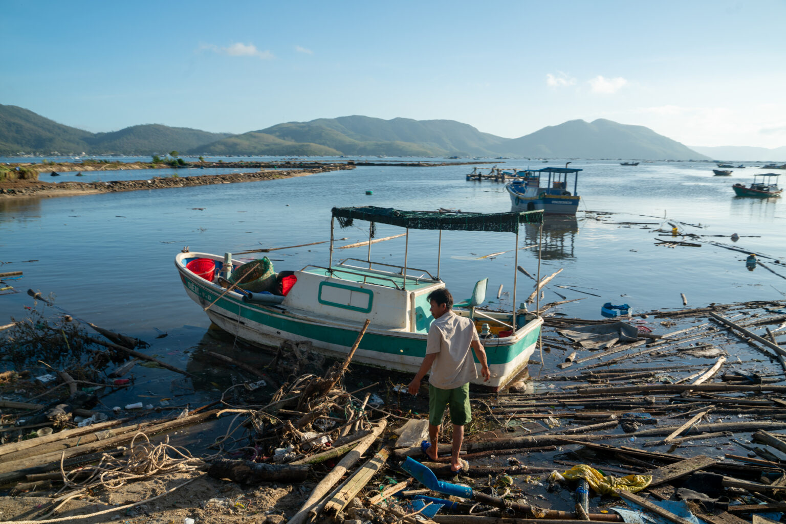 At Xuan Dao Bay, in Vietnam, fishing boats lie destroyed in November 2025 along the shore after being swept away by Typhoon Kalmaegi. leaving many without work. Credit: Magdalena Chodownik/Anadolu via Getty Images