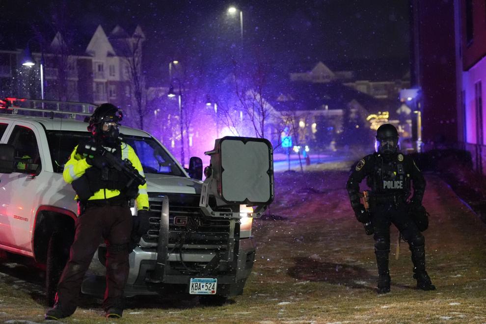 Law enforcement officers stand next to an LRAD (long-range acoustic device) during a protest outside SpringHill Suites and Residence Inn by Marriott hotels on Monday, Jan. 26, 2026, in Maple Grove, Minn.