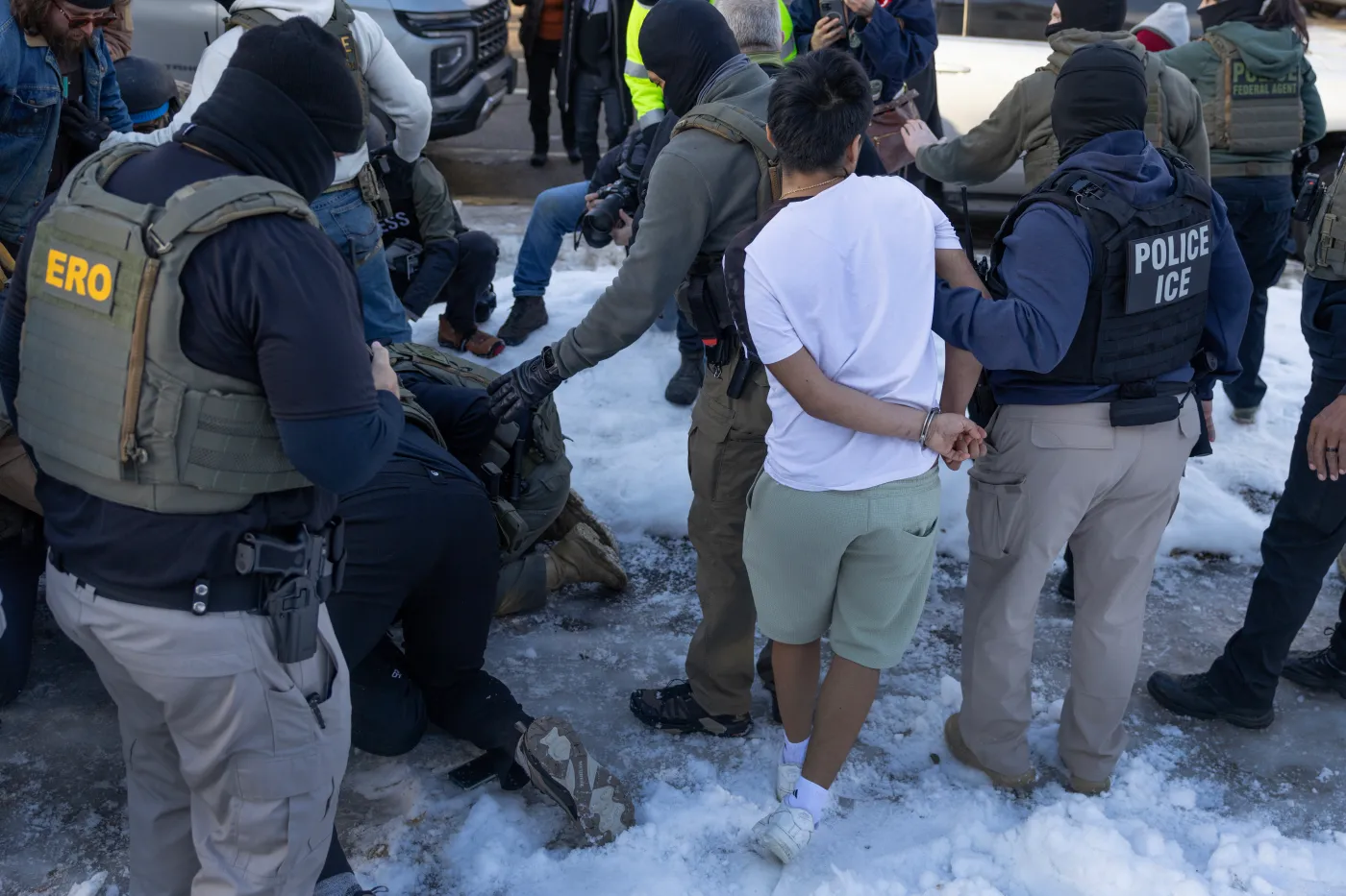 Federal agents clash with residents as they take a person into custody during a house raid on January 13, 2026, in Minneapolis. (Photo by Scott Olson/Getty Images)