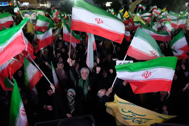 Pro-government demonstrators wave Iranian flags during a gathering in Tehran, Iran [File: Vahid Salemi/AP]