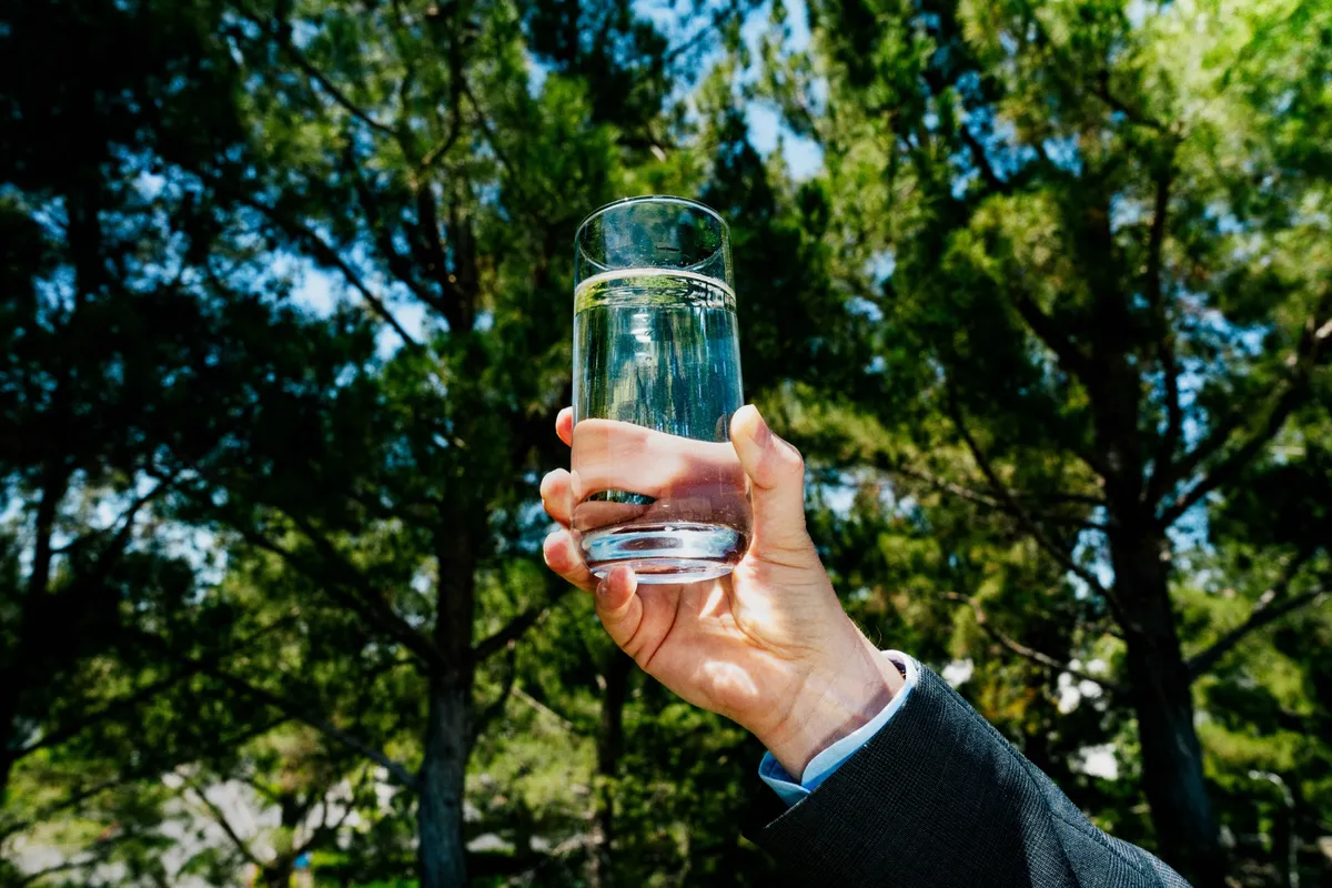 Drinkable water from the unit is held by an Atoco team member.Photographer: Ethan Noah Roy/Bloomberg