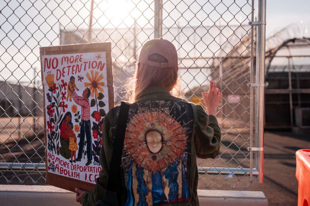 A protester holds a sign by the outer fence at Delaney Hall Immigration Detention Center on June 4, 2026, in Newark, New Jersey.