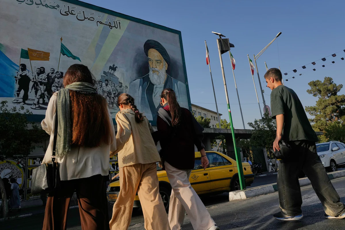 A mural depicting the late Iranian revolutionary founder Ayatollah Ruhollah Khomeini looms over pedestrians in Tehran on Saturday. (Vahid Salemi/AP) A mural depicting the late Iranian revolutionary founder Ayatollah Ruhollah Khomeini looms over pedestrians in Tehran on Saturday. (Vahid Salemi/AP)