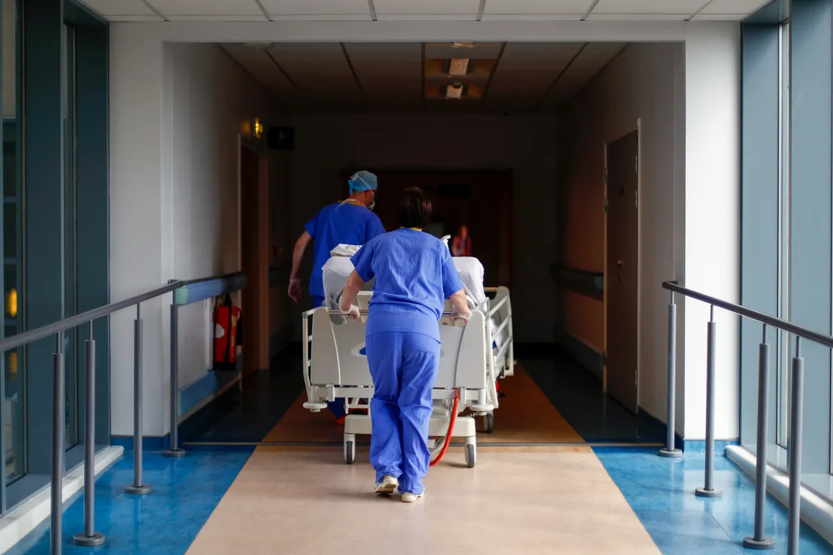 Medical staff transfer a patient along a corridor at a hospital in Blackburn, UK