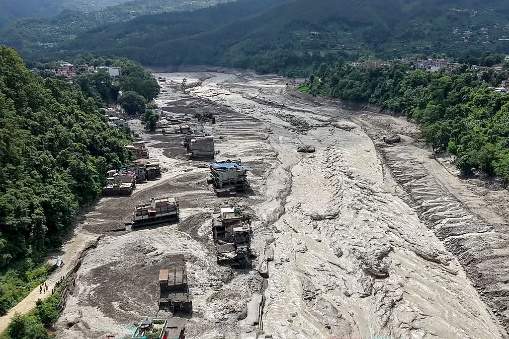 Houses lie partially submerged in muddy water along a riverside after flash floods at Trishuli Bazar in Nepal's Nuwakot district on August 26, 2026. Photo by Prabin RANABHAT / AFP via Getty Images)