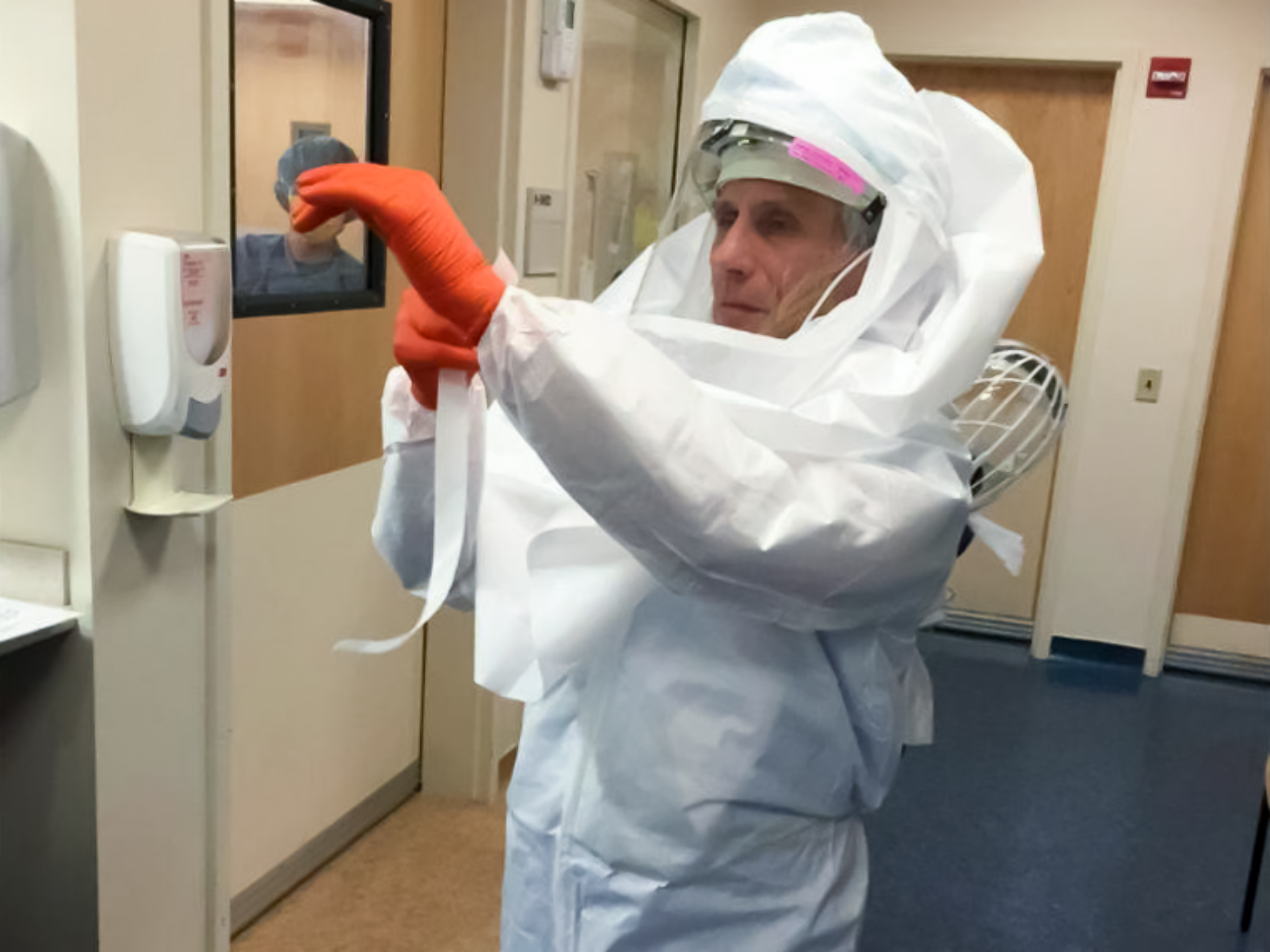 Fauci donning his protective suit. NIH Fauci donning his protective suit. NIH