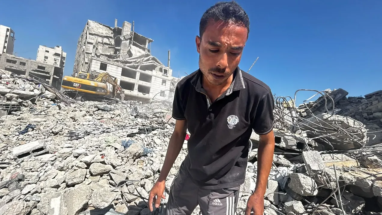 Amr Adas searches for the belongings of his children after last week’s building collapse in Gaza City. Photo by Mohammed Al-Astal