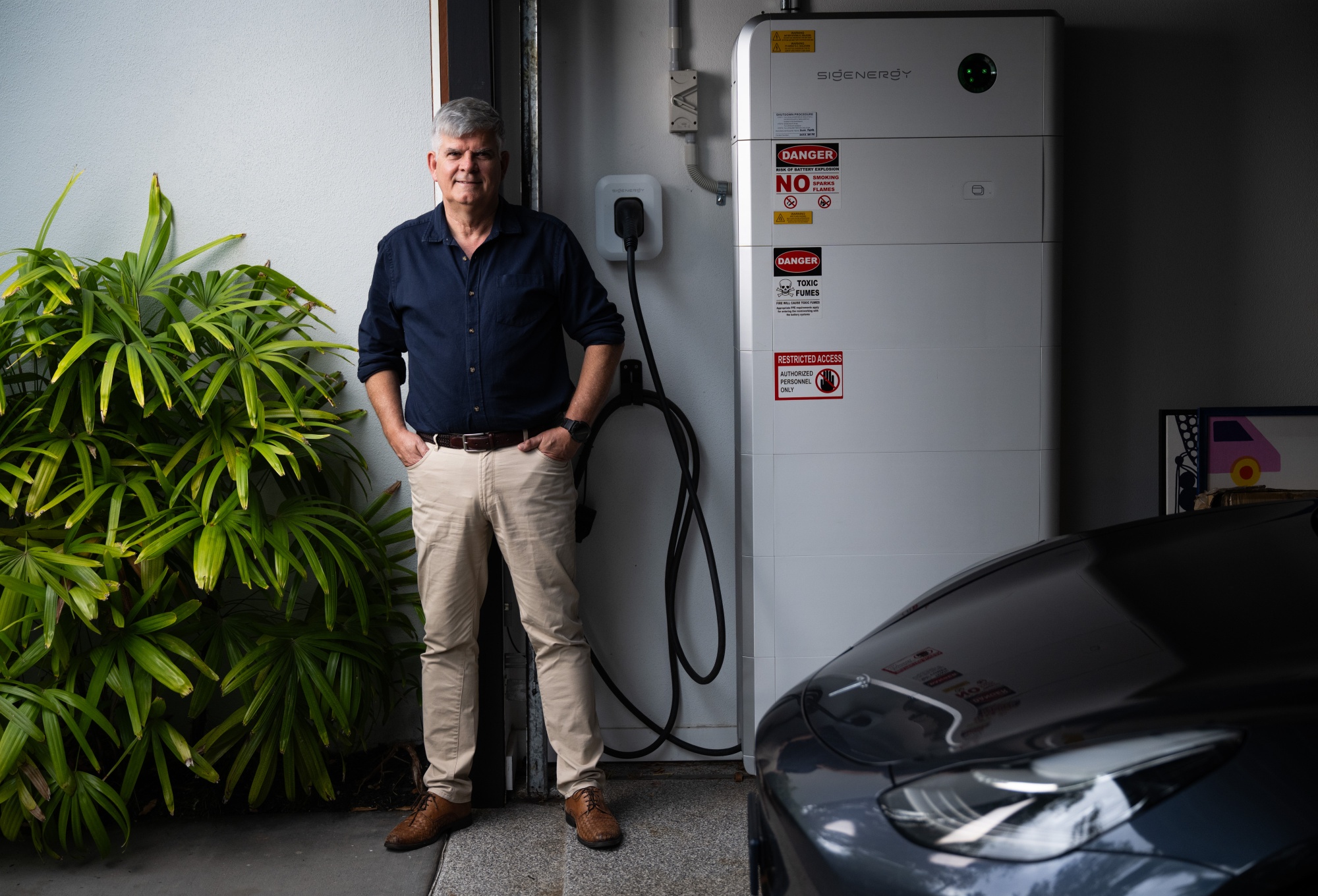 Mark Purcell, an electrical engineer, next to his electric car and 40kWh solar battery in Queensland, Australia. He buys energy when prices are low, stores it, then sells it back to his utility for a profit.Photographer: Dan Peled/Bloomberg