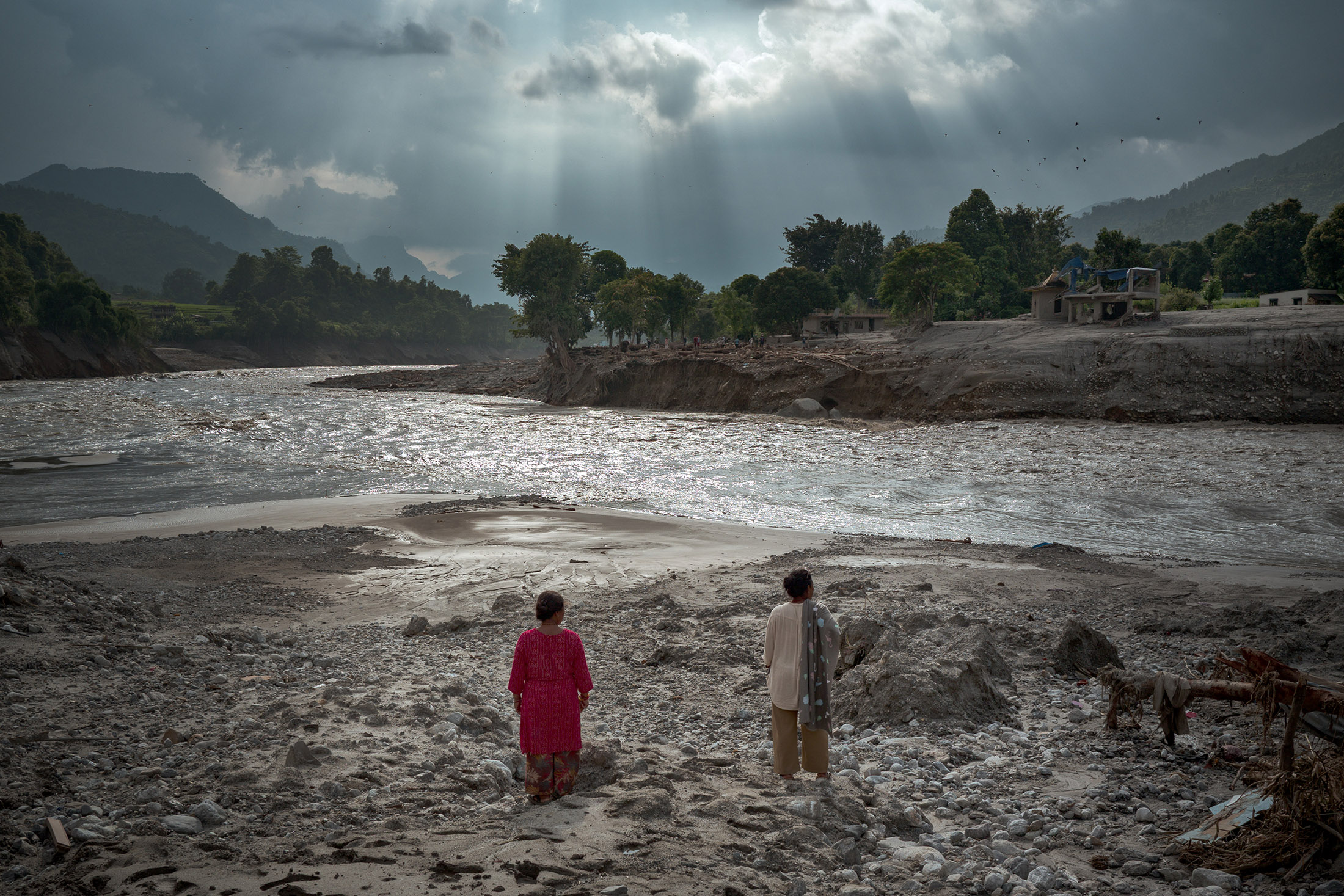 Women view the newly widened Trishuli River following the flash floods in Devighat, Nepal.Photographer: Ezra Acayan/Getty Images AsiaPac