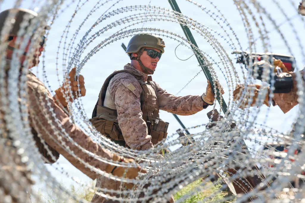 Marines secure concertina wire onto a secondary expeditionary barrier in Nogales, Arizona, Aug. 19, 2026. (Cpl. Alan Gomez/Marine Corps)